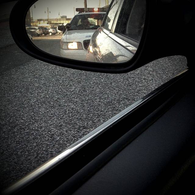 View of a police car from a side view mirror
