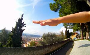 A raised hand with a panoramic street background