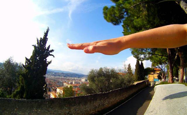 A raised hand with a panoramic street background