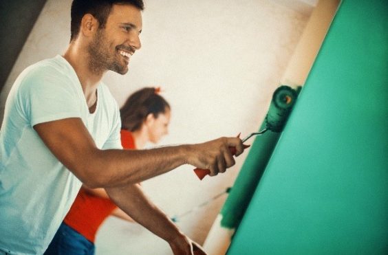 man and womain painting a wall green