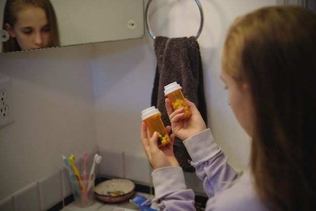 child examining prescription medicine bottles