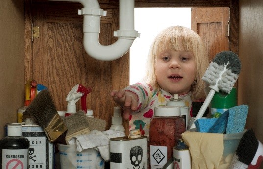 child reaching under a sink